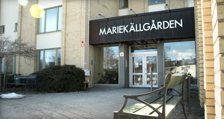 Gul tegelfasad med ingång Mariekällgården