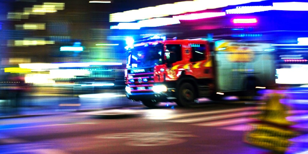 En brandbil under utryckning i mörker.