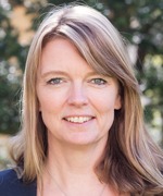 närbild på Marie Härstedt, HR-chef i Lomma kommun. Marie har långt hår och står utomhus med ett grönt träd skymtande i bakgrunden.