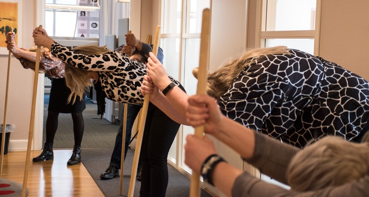 Medarbetare på kontor gör pinngympa som rörelse på arbetstid.