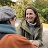 två personer sitter och pratar med varandra utomhus.