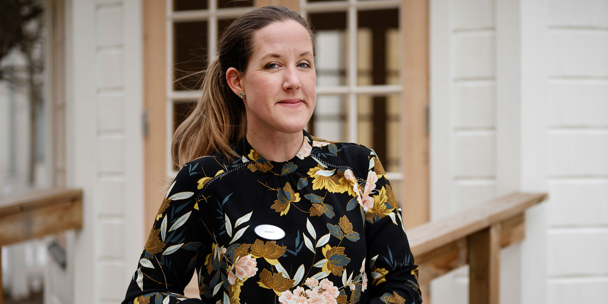 Jenny Häggström lutar sig mot ett räcke utanför sin arbetsplats.