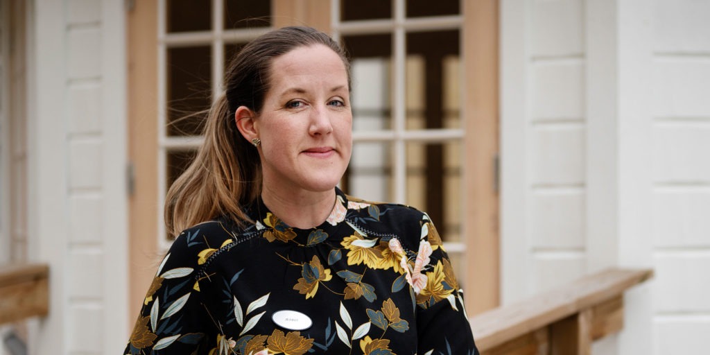 Jenny Häggström lutar sig mot ett räcke utanför sin arbetsplats.