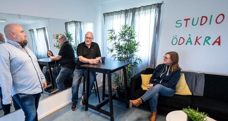 En grupp människor pratar inne på en fritidsgård. En av dem sitter i en fåtölj. De andra två står upp. I bakgrunden en gigantisk spegel och texten Studio Ödåkra.