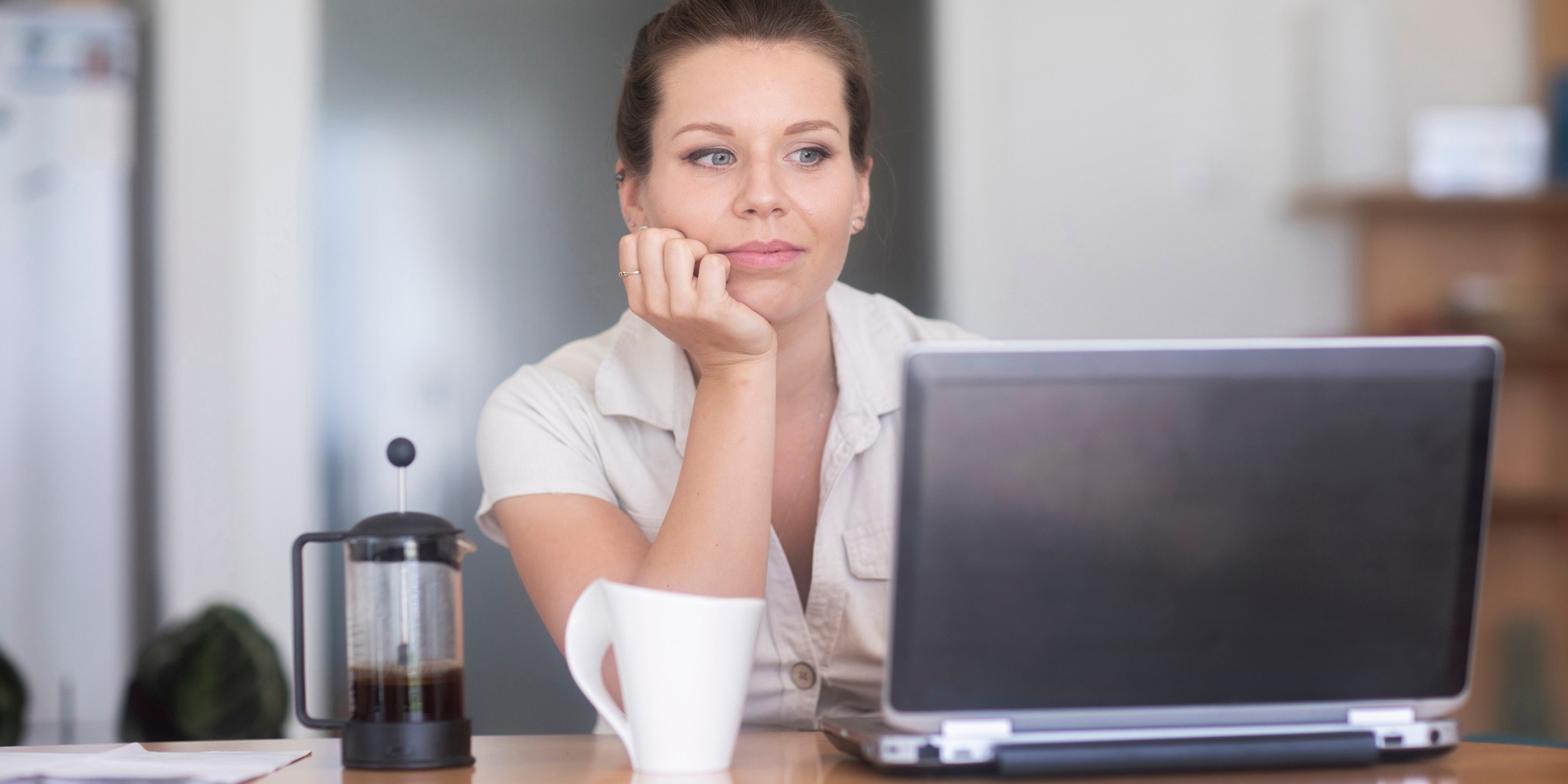 En kvinna sitter vid en laptop och ser avslappnad ut, tema hjärnvänlig arbetsplats.