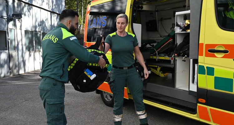 Ambulanssjukvårdarna lastar ur en väska ur bilen