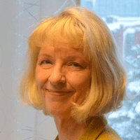 Professor Kristina Alexanderson forskar om barnafödande och sjukfrånvaro vid sitt skrivbord på Karolinska institutet