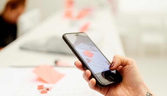 Bild på en kvinnas hand som håller i en mobiltelefon