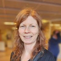 Porträttbild av Pernilla Lindmark Gyllensvaan, fotat i en sjukhuskorridor.