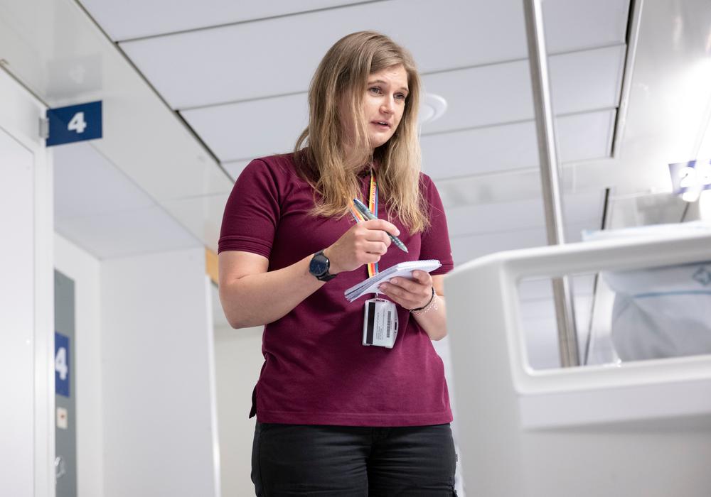 Sofia Bolin, biståndshandläggare, tar anteckningar vid en sjuksäng, där patienten inte syns i bild.