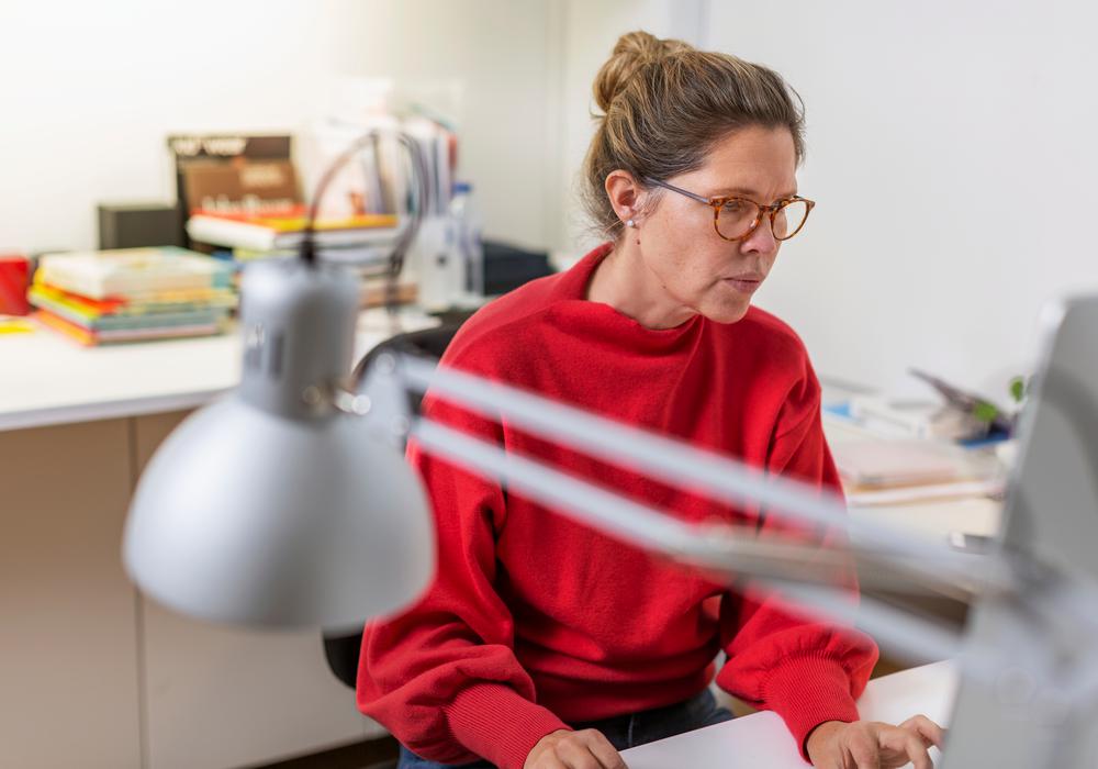 Koncentrerad kvinna framför dator på kontor