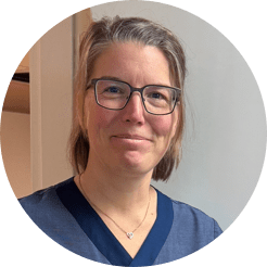 En kvinna i blå vårdklädeströja och glasögon. Sjuksköterskan Marlene Sundin.