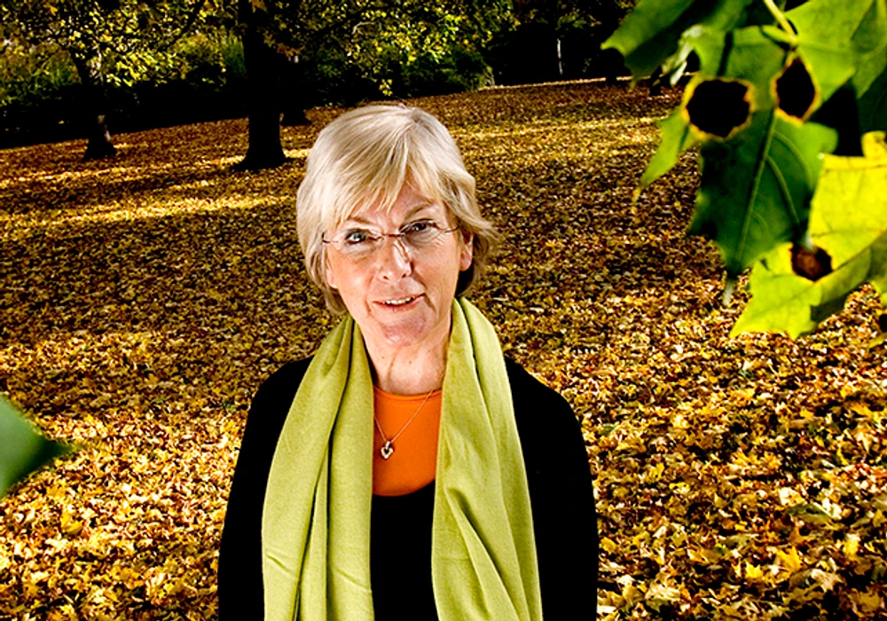 Eva Vingård står i ett höstlandskap.