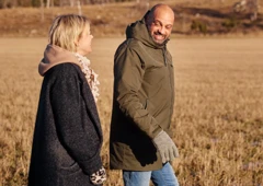 en man och en kvinna ute och går i soligt höstlandskap.
