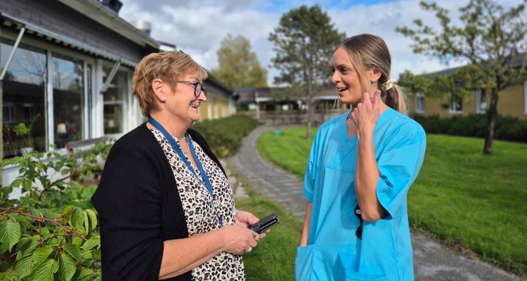 Chef och medarbetare på Älandsgården står på innergården och pratar om hur de minskat hot och våld på demensboendet.