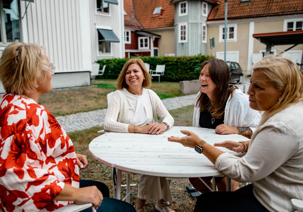 Gruppen som planerar Karlshamns arbetsmiljövecka sitter utomhus runt ett bord.