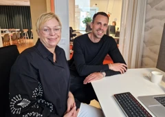 En man och en kvinna sitter vid ett skrivbord framför en dator.