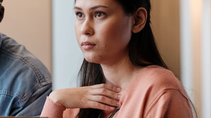 En kvinna pratar om digitala aggressioner och ser bekymrad ut.