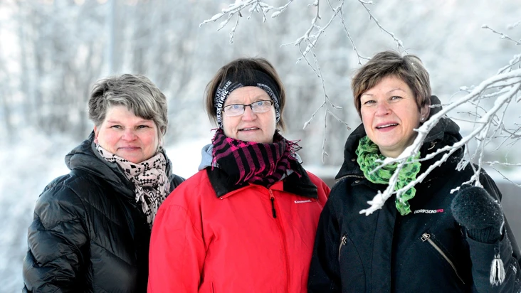 Tre kvinnor står bredvid varandra i snön.