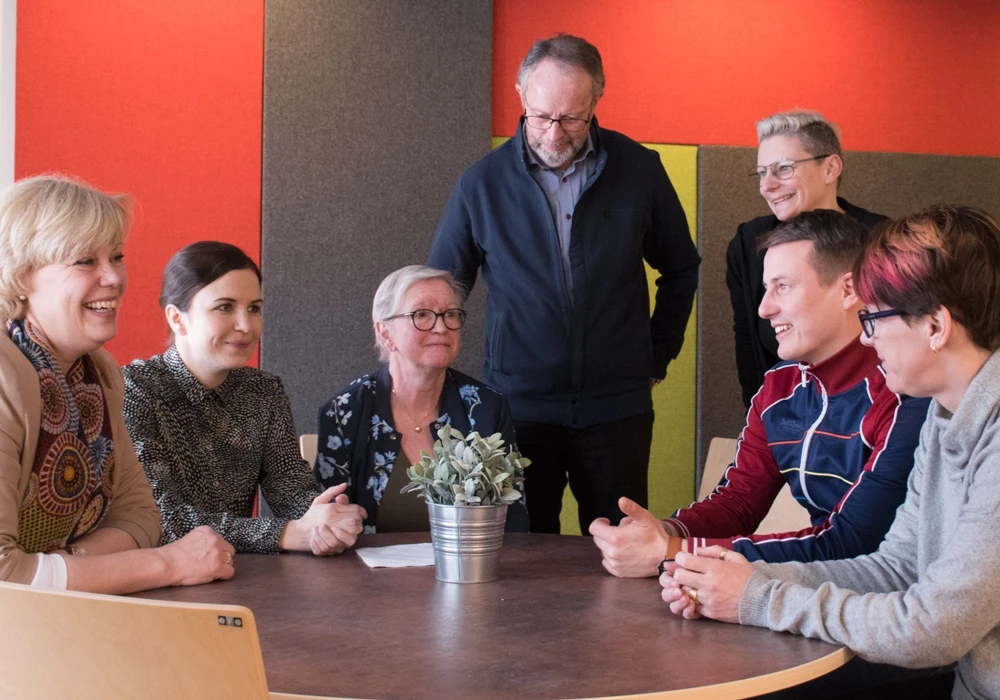 En grupp sitter i ett möte i ett rum.
