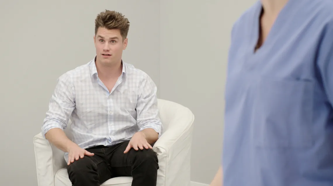 En nyvaken man i en fåtölj.