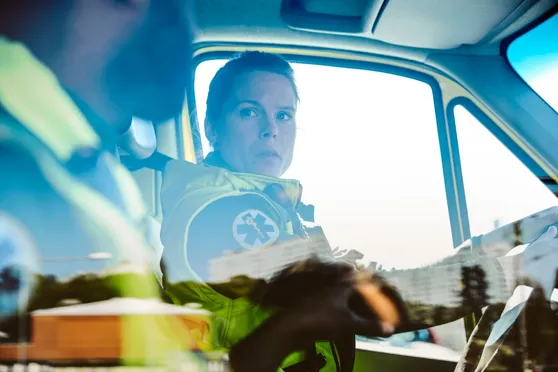 Två personer sitter i en ambulans.