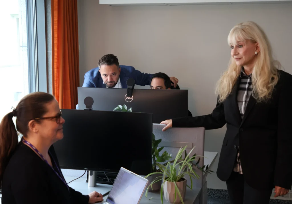 Glada kollegor samarbetar vid skrivbord.